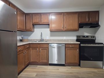 Baldwinsville apartment for rent - A kitchen with wooden cabinets and stainless steel appliances.