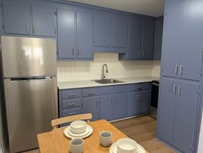 Waynesboro apartment for rent - A kitchen with blue cabinets and a stainless steel refrigerator.