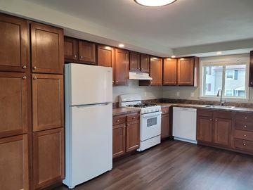 Manlius apartment for rent - A kitchen with wooden cabinets and white appliances.