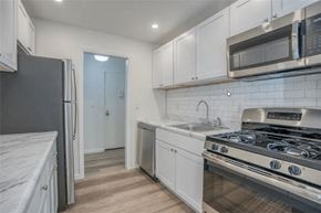 Kingston apartment for rent - a kitchen with white cabinets and stainless steel appliances