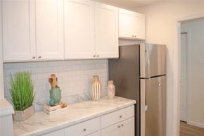 Kingston apartment for rent - a kitchen with white cabinets and a refrigerator