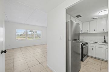Merritt Island apartment for rent - A kitchen with white cabinets and a stainless steel refrigerator.