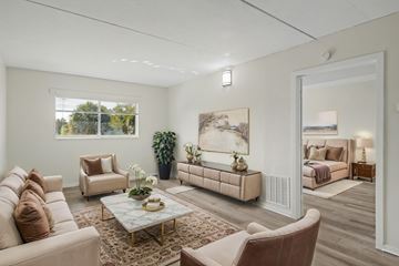 Merritt Island apartment for rent - A living room with a large painting on the wall and a couch with a pillow on it.