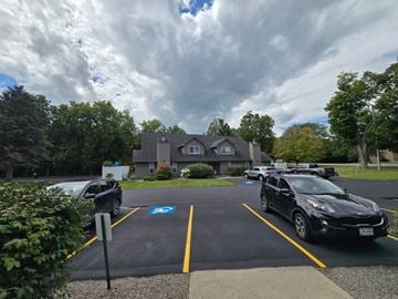 Manlius apartment for rent - A black car is parked in a parking space with a blue wheelchair symbol.