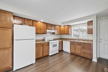 Manlius apartment for rent - A kitchen with wooden cabinets and a white refrigerator.