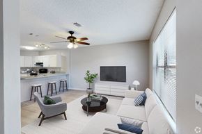 Pensacola apartment for rent - A living room with a grey armchair, a white sofa, and a black coffee table.
