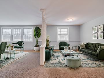 Baldwinsville apartment for rent - A living room with a green couch and a glass table.