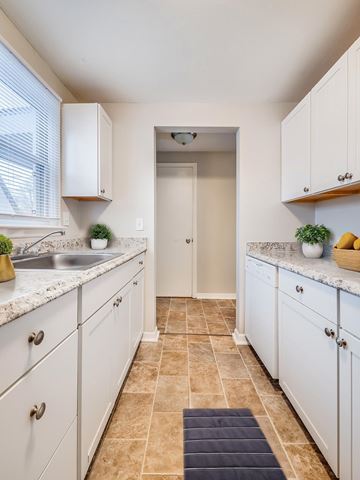 Manlius apartment for rent - A kitchen with white cabinets and a tiled floor.