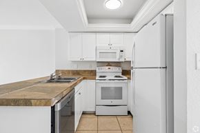 Fort Myers apartment for rent - A kitchen with white cabinets and appliances.