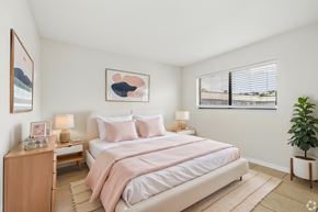 Fort Myers apartment for rent - A bedroom with a large bed and a potted plant.