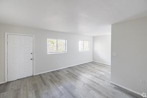 Fort Myers apartment for rent - A room with a white door and two windows with wooden flooring.