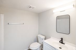 Fort Myers apartment for rent - A white toilet sits next to a white sink in a small bathroom.