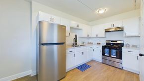 Merritt Island apartment for rent - A kitchen with a stainless steel refrigerator and white cabinets.