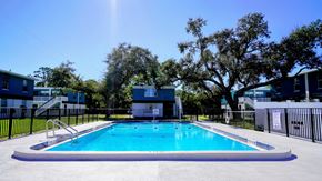 Merritt Island apartment for rent - A swimming pool surrounded by trees and buildings.