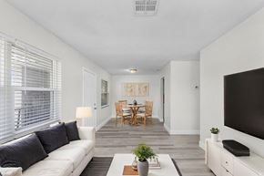 Fort Myers apartment for rent - A living room with a white couch, a wooden table, and a television.