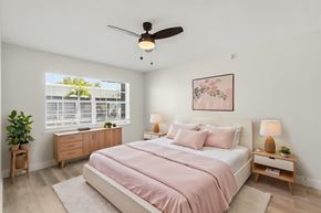 Fort Myers apartment for rent - A bedroom with a pink bedspread and a ceiling fan.
