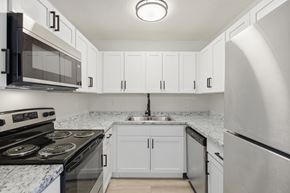 Fort Myers apartment for rent - A kitchen with white cabinets and a marble countertop.