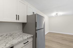 Fort Myers apartment for rent - A kitchen with a marble countertop and a stainless steel refrigerator.