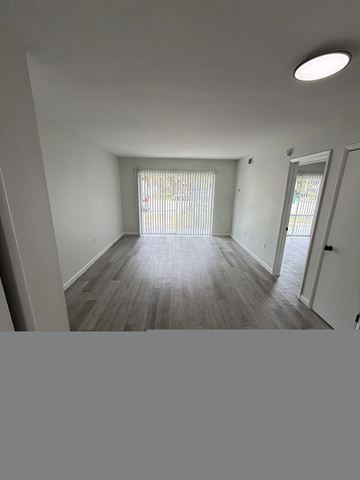 Cape Canaveral apartment for rent - A room with a window and a wooden floor.