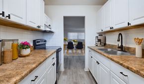 Merritt Island apartment for rent - A kitchen with white cabinets and a brown countertop.