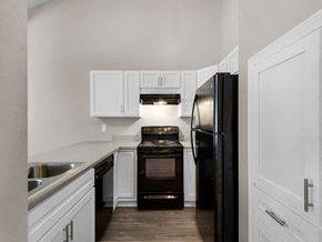 Pensacola apartment for rent - a kitchen with black appliances and white cabinets