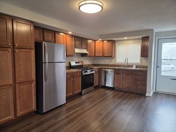 Manlius apartment for rent - A kitchen with wooden cabinets and a refrigerator.