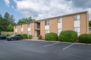 Staunton apartment for rent - A parking lot in front of a brick apartment building.