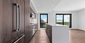 Washington apartment for rent - A modern penthouse kitchen with dark wood cabinets and a white island.