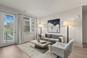 Germantown apartment for rent - A living room with a grey couch, a grey armchair, a coffee table, and a painting on the wall.