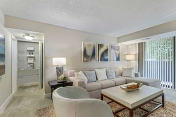 Alexandria apartment for rent - A living room with a white couch, a glass table, and a painting on the wall.
