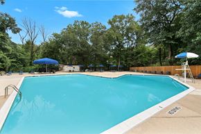 Springfield apartment for rent - A large blue swimming pool surrounded by trees and a fence.