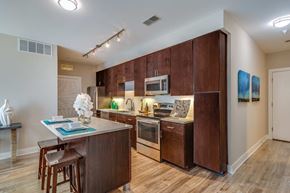 Dulles apartment for rent - A kitchen with brown cabinets and a wooden island.