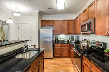 Fairfax apartment for rent - A kitchen with wooden cabinets and black countertops.