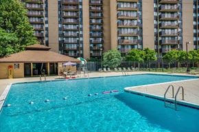 Alexandria apartment for rent - A swimming pool with a diving board and a building in the background.