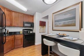 Alexandria apartment for rent - A kitchen with a black counter top and white chairs.