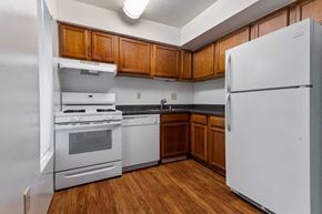 Reston apartment for rent - a kitchen with white appliances and wooden cabinets