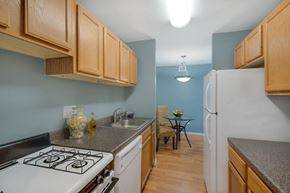 Forestville apartment for rent - A kitchen with a white stove top oven and wooden cabinets.