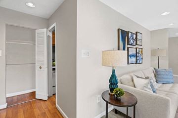 Forestville apartment for rent - A living room with a white couch, a table with a blue lamp, and pictures on the wall.