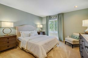 Forestville apartment for rent - A bedroom with a large bed, two nightstands, and a window with curtains.