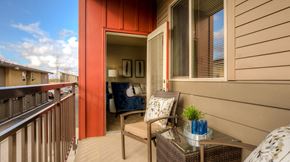 Renton apartment for rent - a balcony with a chair and a table and a door to a living room