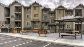 Renton apartment for rent - an empty parking lot with benches in front of an apartment building