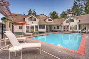 Everett apartment for rent - A pool and lounge chairs are in front of a house.
