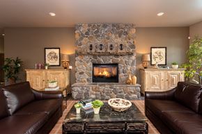 Vancouver apartment for rent - a living room with a stone fireplace and brown couches