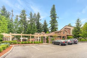 Renton apartment for rent - a parking lot with cars in front of a building with trees