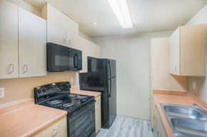 Renton apartment for rent - a kitchen with black appliances and white cabinets