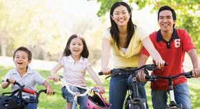 Renton apartment for rent - A family of four riding bikes together in a park.
