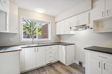Gatineau apartment for rent - A kitchen with white cabinets and a window.