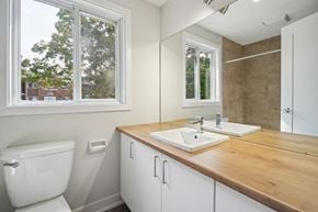 Gatineau apartment for rent - A bathroom with a toilet, sink, and mirror.