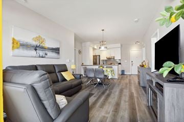 Thurso apartment for rent - A living room with a grey sofa and a painting of a tree on the wall.