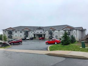 Saint John townhouse for rent - A parking lot in front of a building with cars parked.
